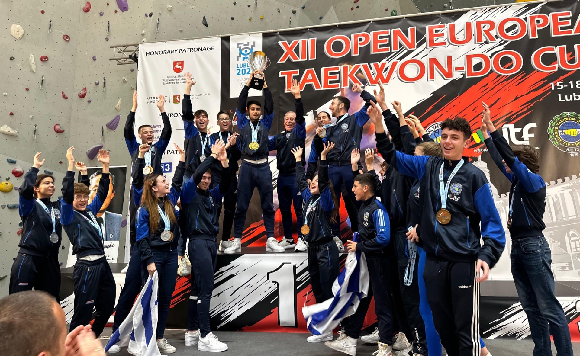 נבחרת המרכז הישראלי לטאיקוון-דו ITF על פודיום המנצחים בגביע אירופה, עם מדליות, גביע ודגל ישראל