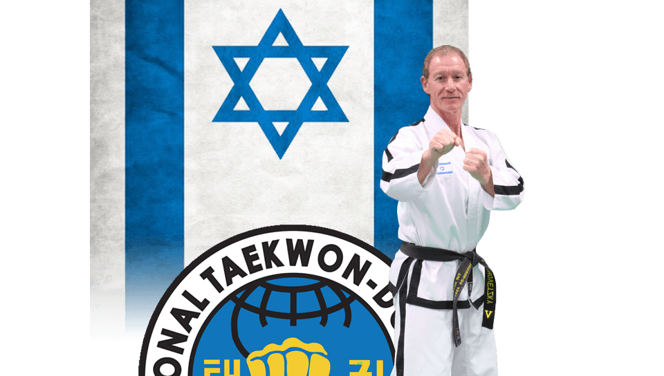 מאמן בחליפת טאיקוון-דו של מדריך וחגורה שחורה עומד בעמידת מוכנות על רקע דגל ישראל וסמל הארגון הבינלאומי לטאיקוון-דו ITF